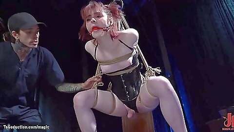 Sexy redhead in a red bikini in a gagging in a strappado bondage